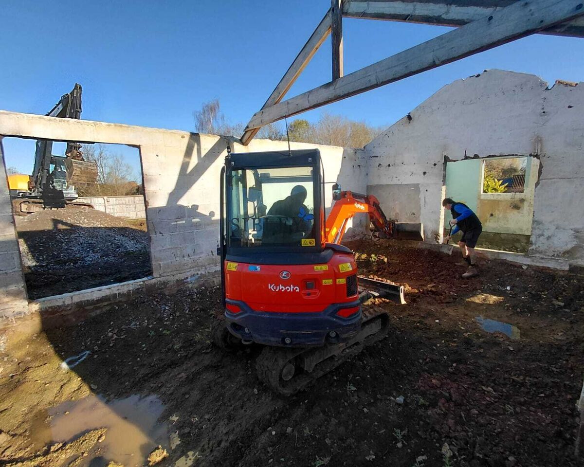 Mini digger excavating inside existing barn, Ashill, Somerset