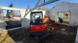 Kubota mini digger excavating inside an existing barn with roof trusses overhead in Ashill, Somerset