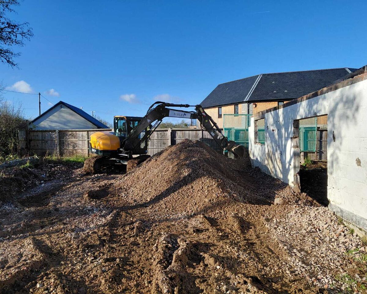 Excavator clearing spoil at barn conversion, Ashill, Somerset